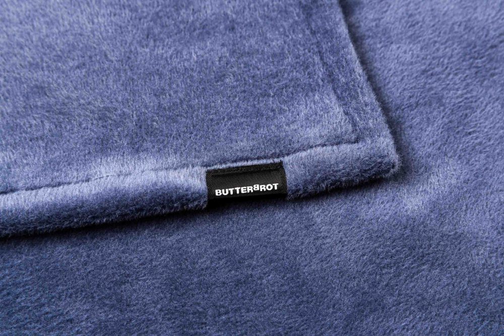 Produktfotografie des Etiketts und Logos auf blauer Hundedecke