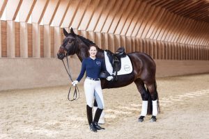 Reiterin Victoria Wurzinger mit Dressurpferd, Reithelm und Tierlicht Poloshirt