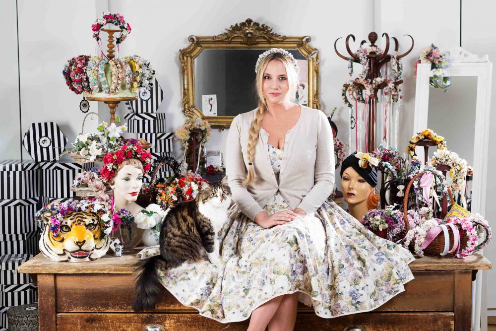 Fotografie einer Katze mit Designerin Niki Osl in ihrem Atelier am Tisch