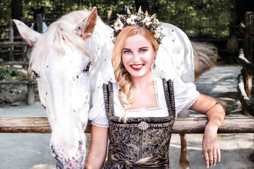 Frau mit weissem Pferd im Dirndl