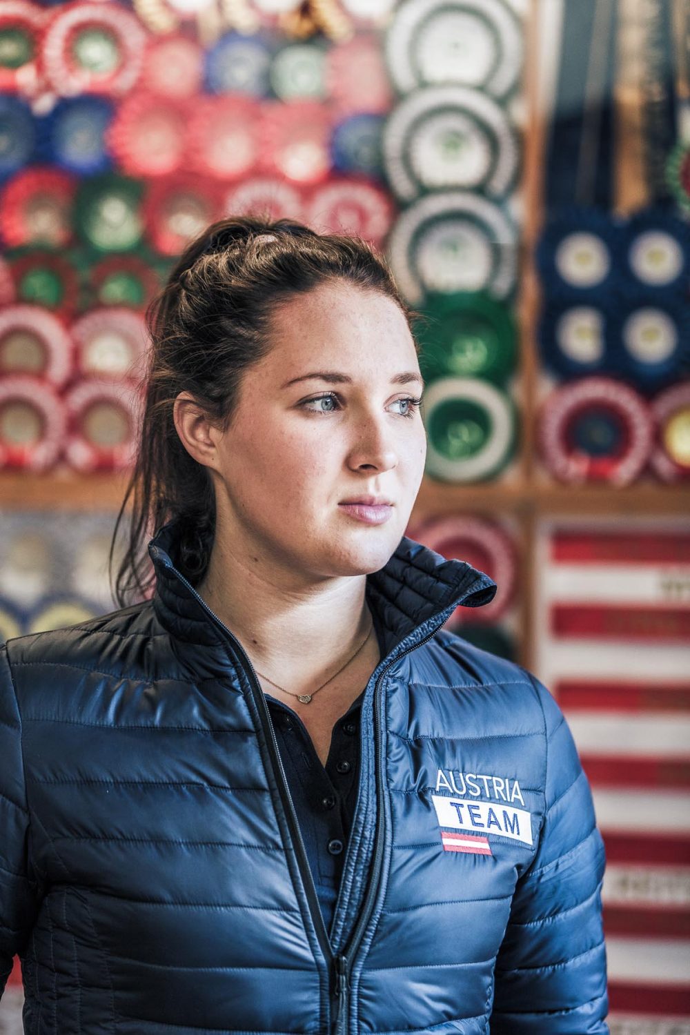 Foto von der mehrfachen österreichischen Staatsmeisterin im Dressurreiten Victoria Wurzinger vor ihren Trophäen porträtiert von Tierlicht