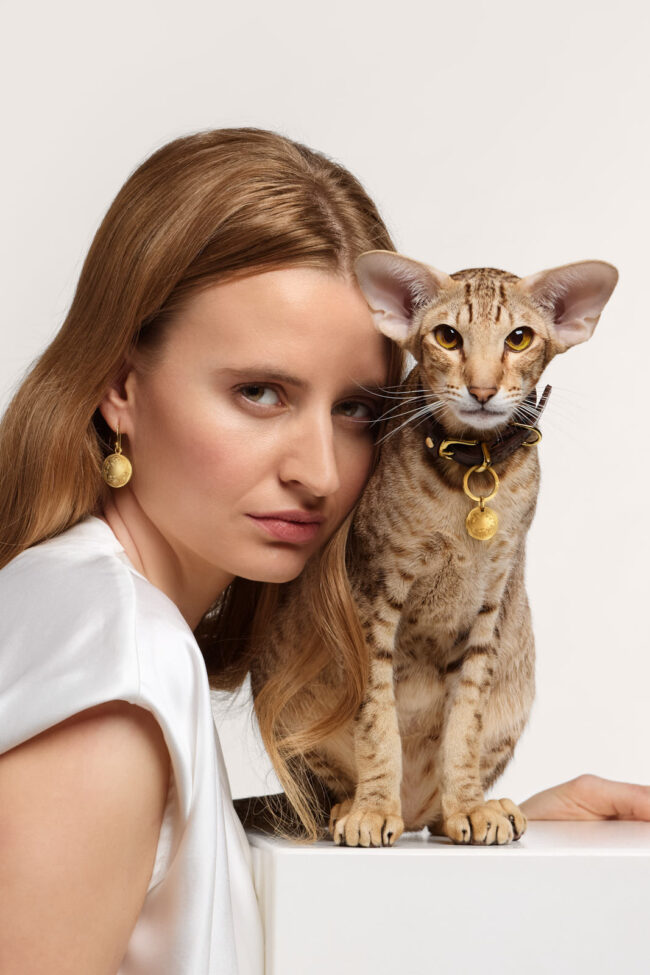 Blondes Fotomodell mit einem getigerten Siam Kater mit Tierschmuck von rondoro Werbekampagne mit Katzen fotografiert von Katzenfotograf Tierlicht Clemens Schneider